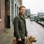 blond man walking dog